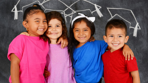 Young students standing in front of a chalkboard