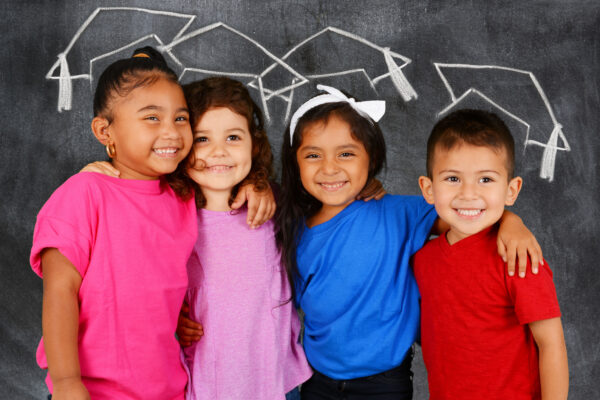 Young students standing in front of a chalkboard