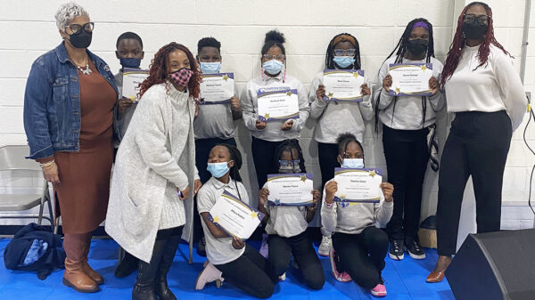 Student participants in the Scholars Engaged for Action program at the Charter School of New Castle pose for a picture with awards for completing their student service project.