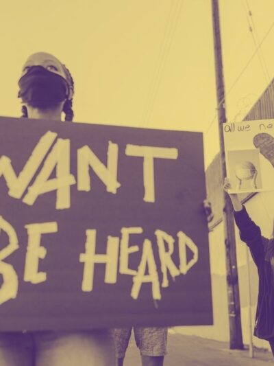 photograph of a person holding a sign that says "I want to be heard."