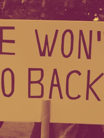 A protestor holding a sign saying, "We Won't Go Back."