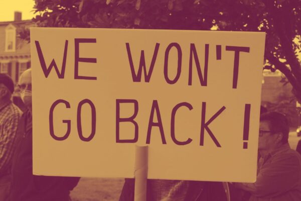 A protestor holding a sign saying, "We Won't Go Back."