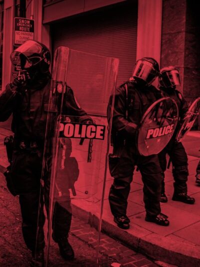 An image of cops in riot gear tinted red.