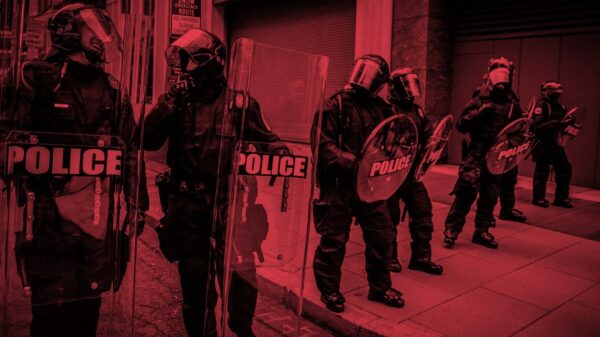 An image of cops in riot gear tinted red.