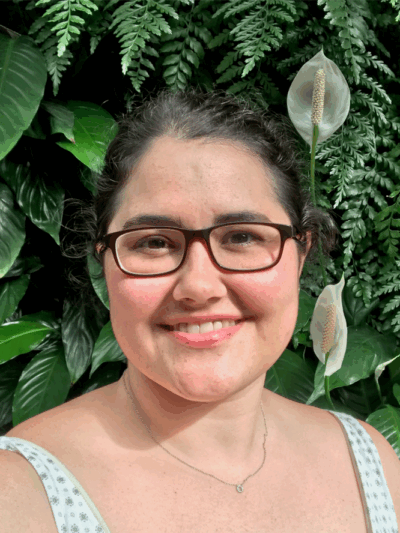 Headshot of Rachael against a plant wall.