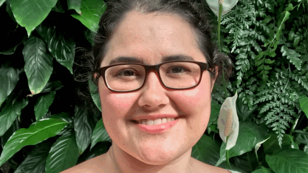 Headshot of Rachael against a plant wall.