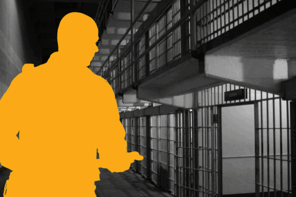 Silhouette of guard standing in front of jail cell