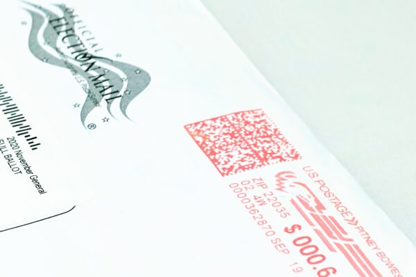Close-up photo of a mail-in ballot, placed diagonally on a white background.