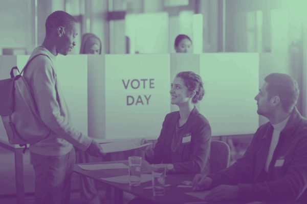 A person holding a paper form and talking to election officials.