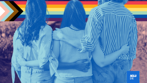 people with their arms around one another and a progress flag in the background