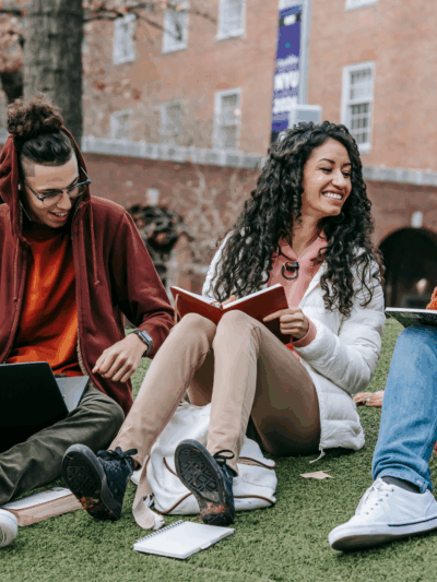 University students sitting on a campus lawn.