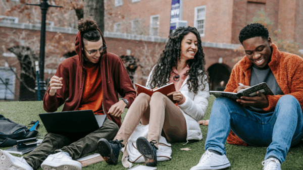 University students sitting on a campus lawn.