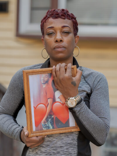 Sharee Congo stands outside of her home, holding a photo of her son, Armani.