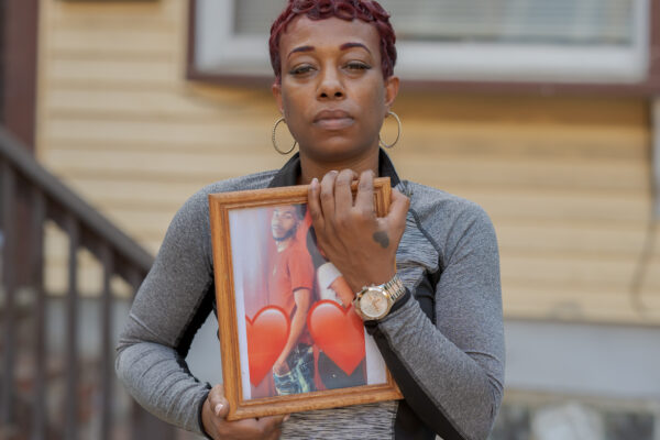 Sharee Congo stands outside of her home, holding a photo of her son, Armani.