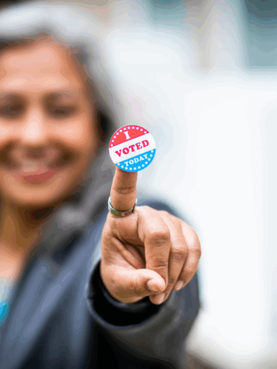 Woman holding "I Voted" sticker