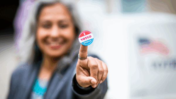 Woman holding "I Voted" sticker