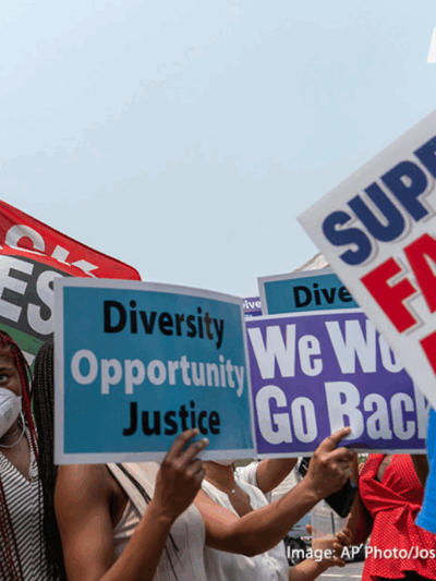 A crowd of protestors holding signs that with "DEI" related slogans like "Diversity, Opportunity, Justice"