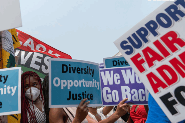 A crowd of protestors holding signs that with "DEI" related slogans like "Diversity, Opportunity, Justice"