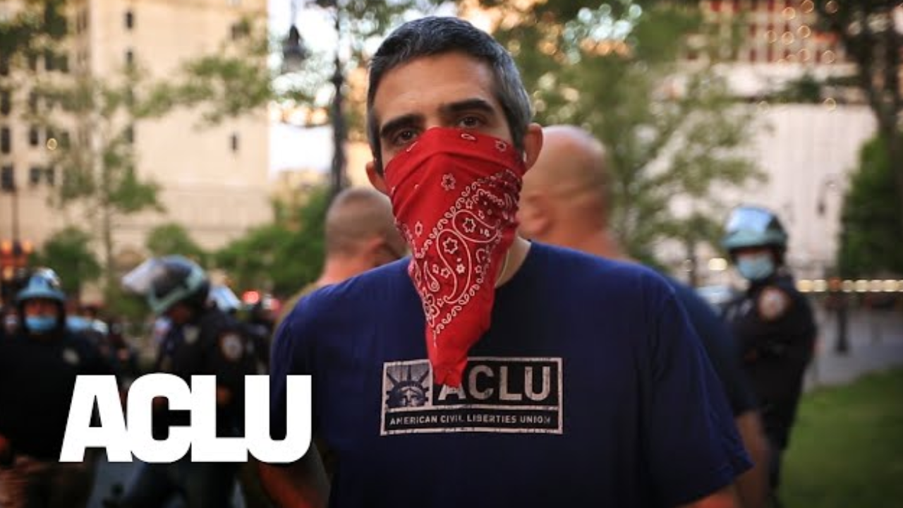 A protestor with his face covered by a bandana