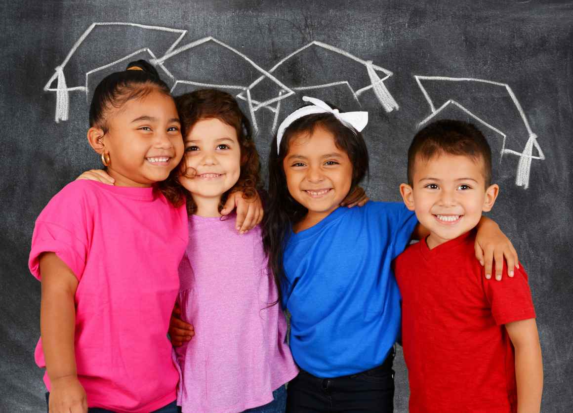 Young students standing in front of a chalkboard