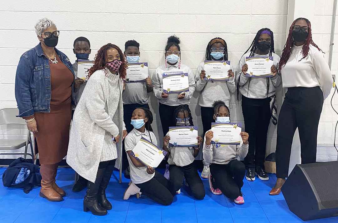 Student participants in the Scholars Engaged for Action program at the Charter School of New Castle pose for a picture with awards for completing their student service project.