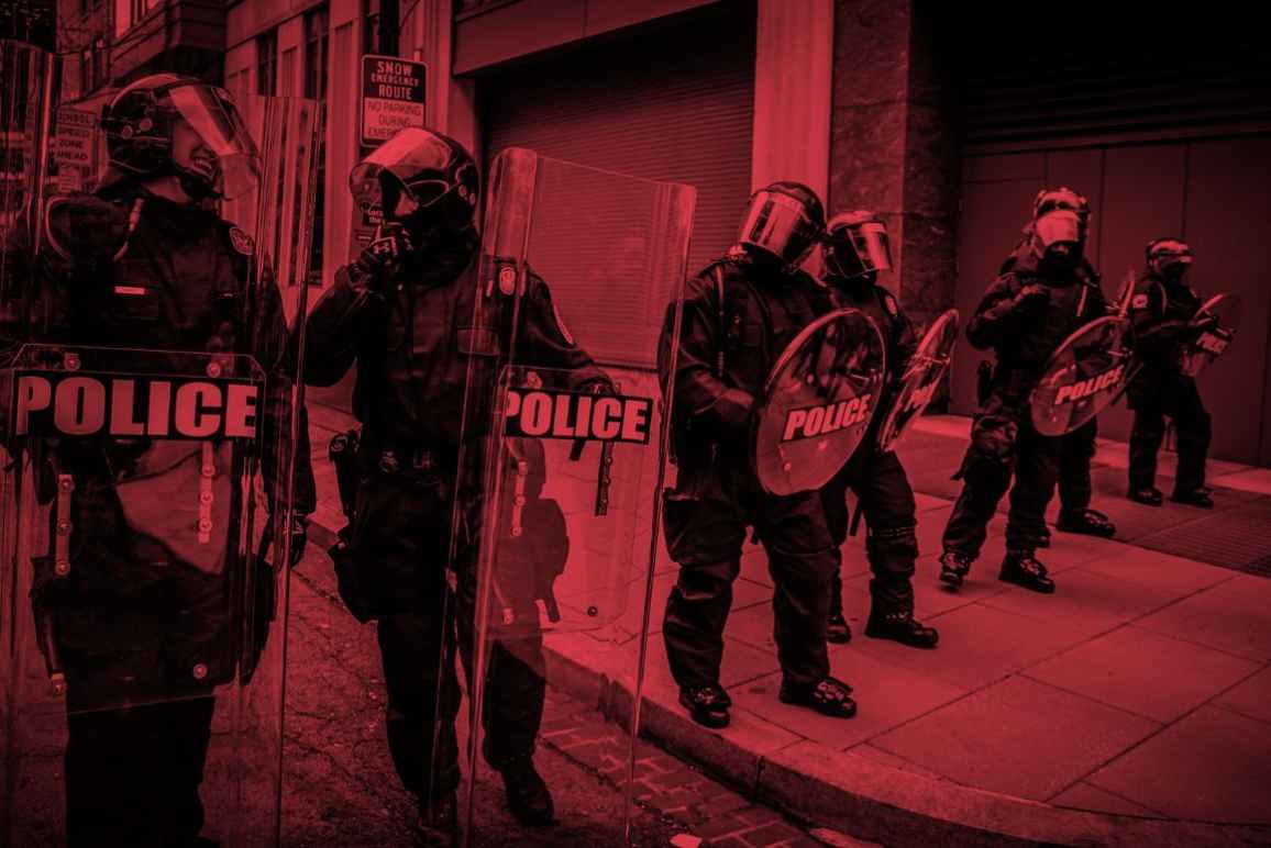 An image of cops in riot gear tinted red.