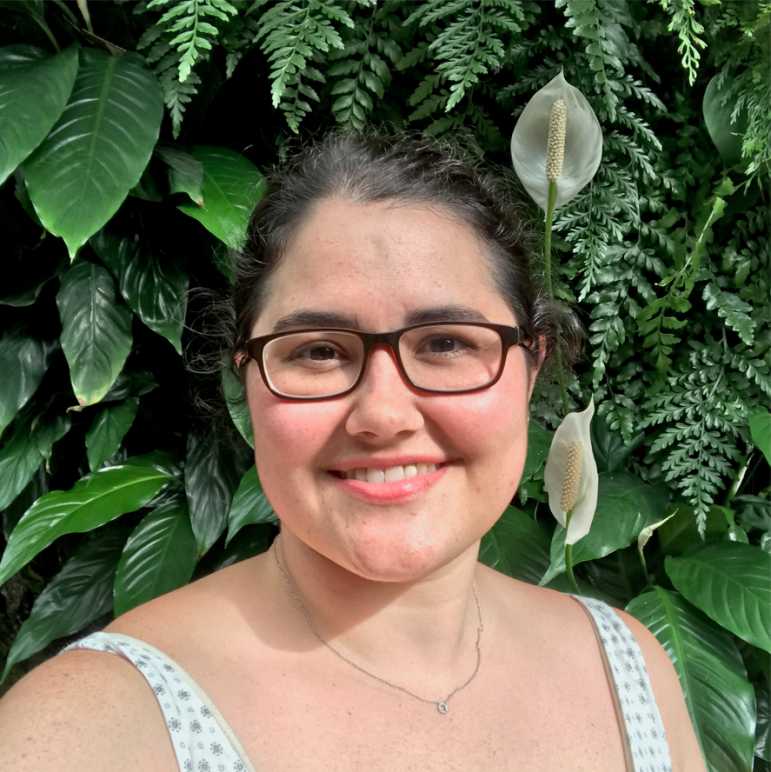 Headshot of Rachael against a plant wall.