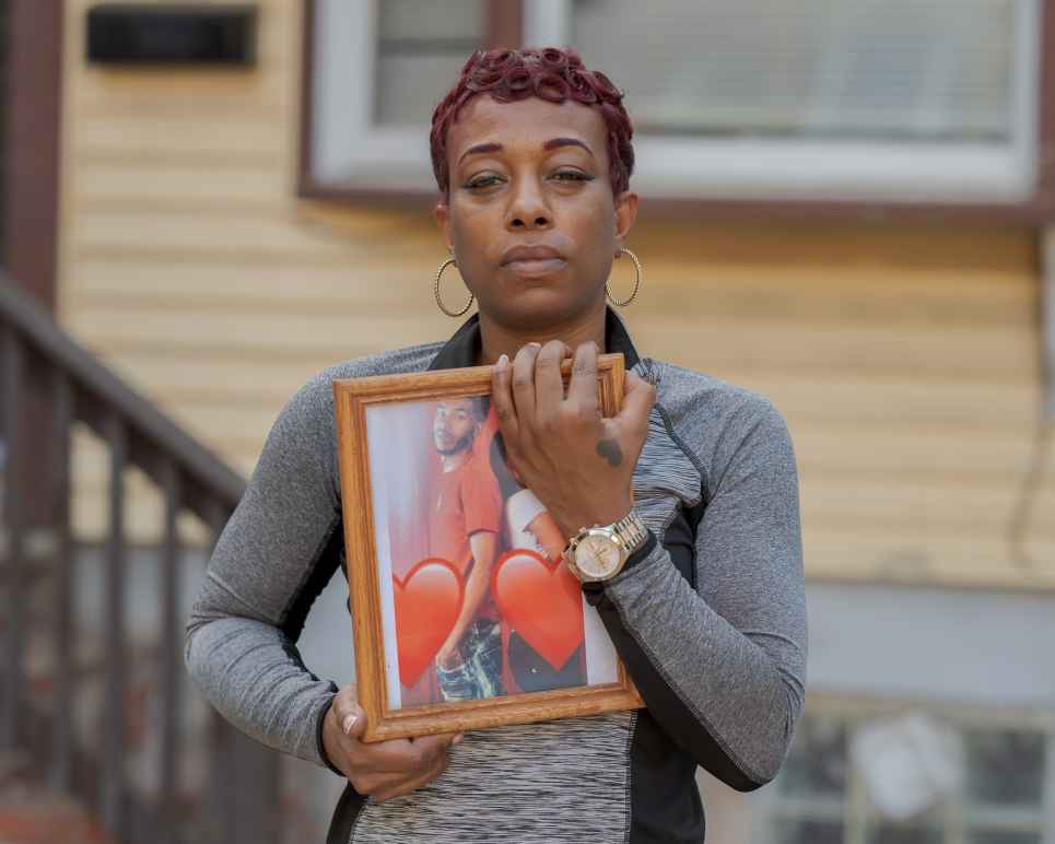 Sharee Congo stands outside of her home, holding a photo of her son, Armani.