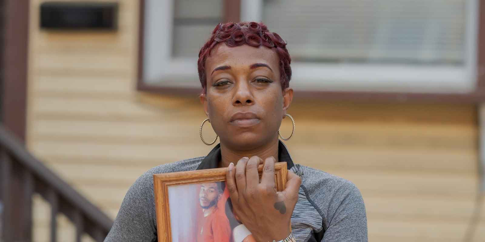 Sharee Congo stands outside of her home, holding a photo of her son, Armani.