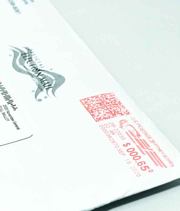 Close-up photo of a mail-in ballot, placed diagonally on a white background.