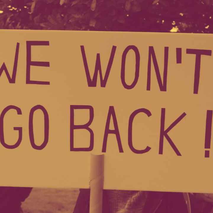 A protestor holding a sign saying, "We Won't Go Back."