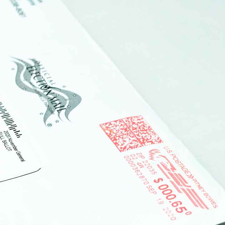Close-up photo of a mail-in ballot, placed diagonally on a white background.