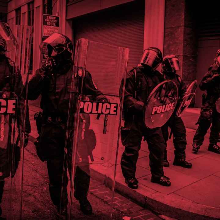 An image of cops in riot gear tinted red.
