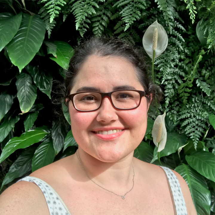Headshot of Rachael against a plant wall.