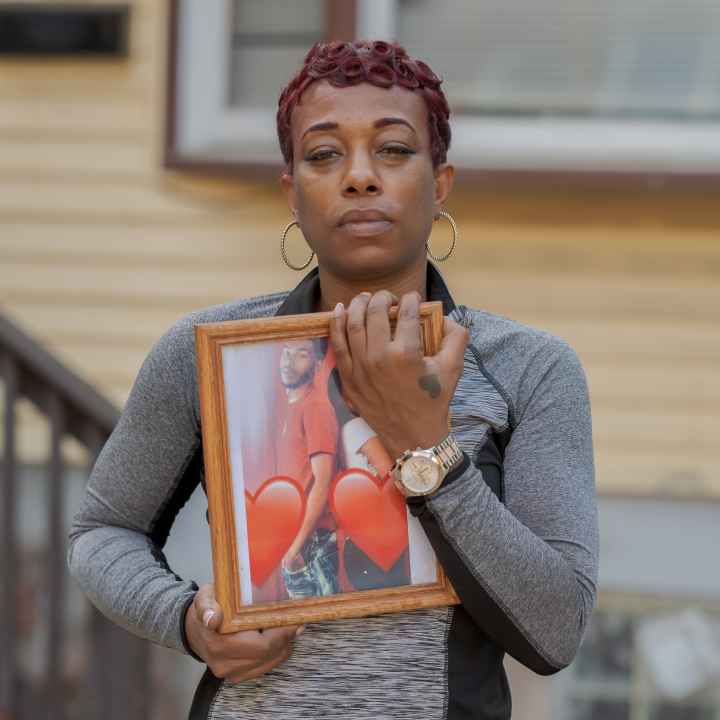 Sharee Congo stands outside of her home, holding a photo of her son, Armani.